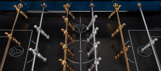 Un petit joueur de babyfoot Bonzini avec le maillot extérieur du PSG